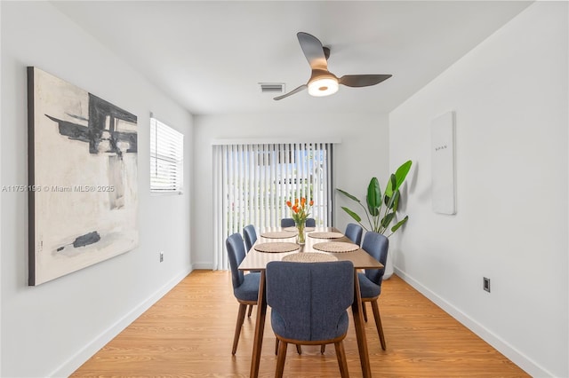 dining area featuring light wood-style floors, visible vents, baseboards, and a ceiling fan