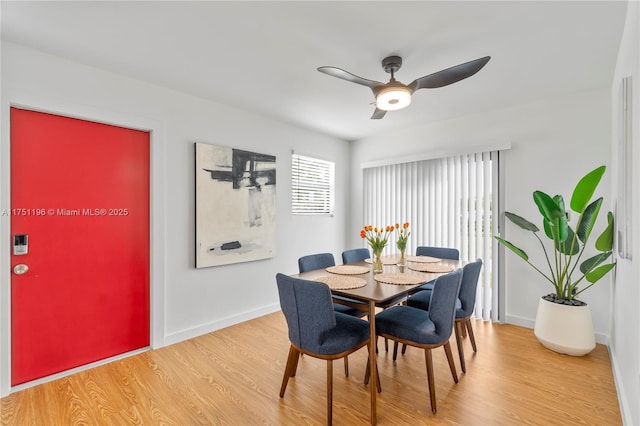 dining space with a ceiling fan, light wood-type flooring, and baseboards