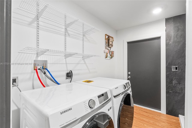 laundry area featuring laundry area, washer and clothes dryer, and wood finished floors