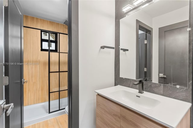 bathroom featuring toilet, wood finished floors, and vanity