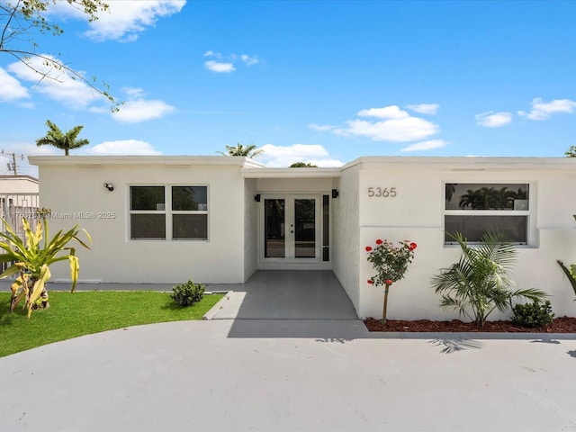 view of exterior entry featuring french doors and stucco siding