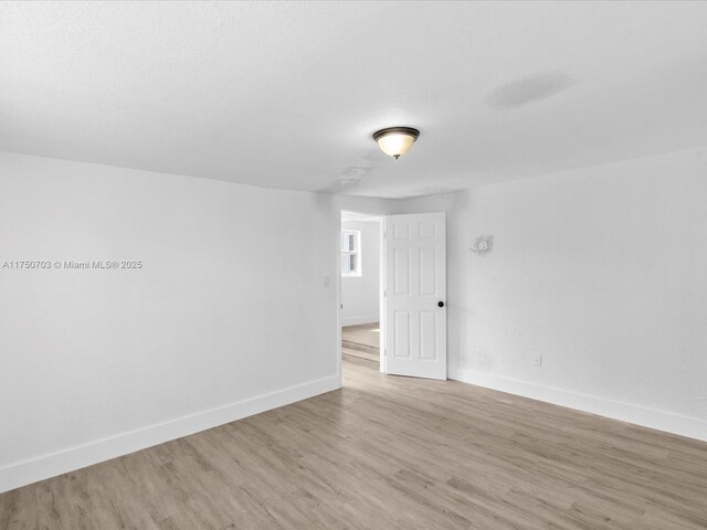 unfurnished room featuring baseboards and wood finished floors