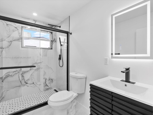 bathroom featuring toilet, a marble finish shower, and vanity