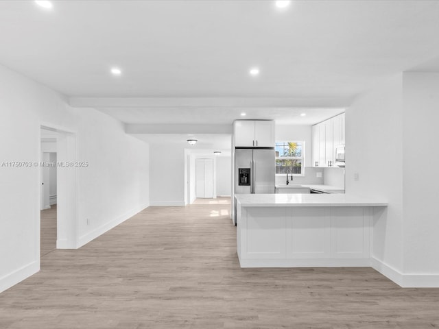 kitchen with white cabinets, light wood-type flooring, light countertops, and stainless steel fridge with ice dispenser