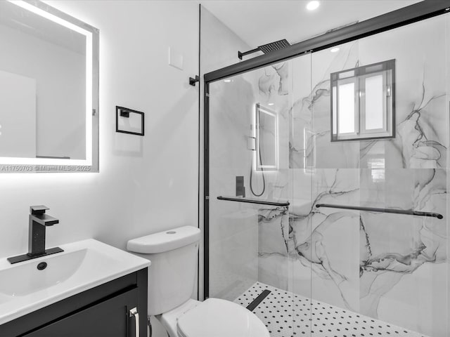 bathroom featuring toilet, a marble finish shower, and vanity