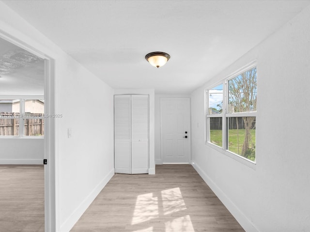 spare room featuring baseboards and wood finished floors