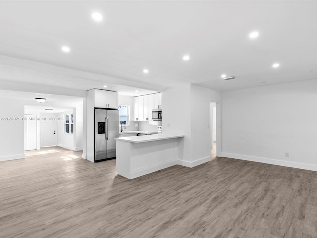 kitchen with light wood-type flooring, recessed lighting, stainless steel appliances, and open floor plan