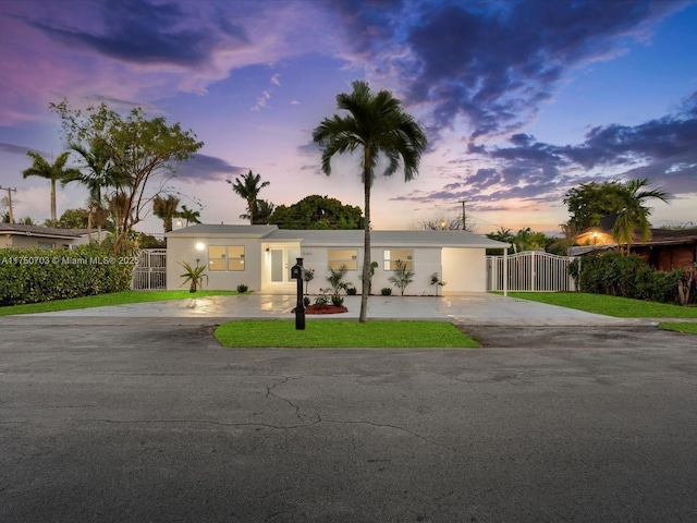 view of front facade with driveway, a gate, and stucco siding