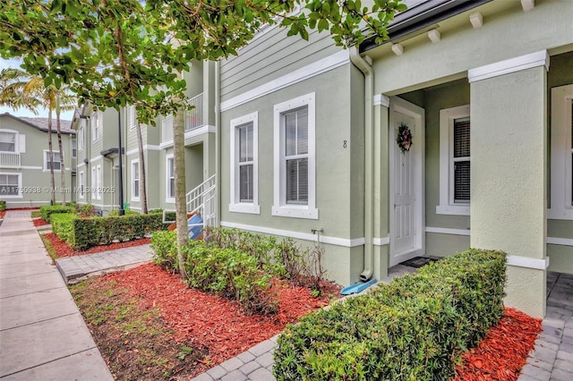 doorway to property featuring stucco siding