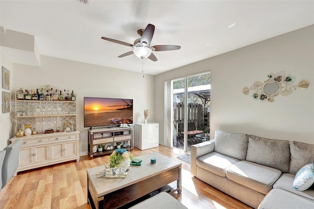 living room with ceiling fan and light wood-type flooring