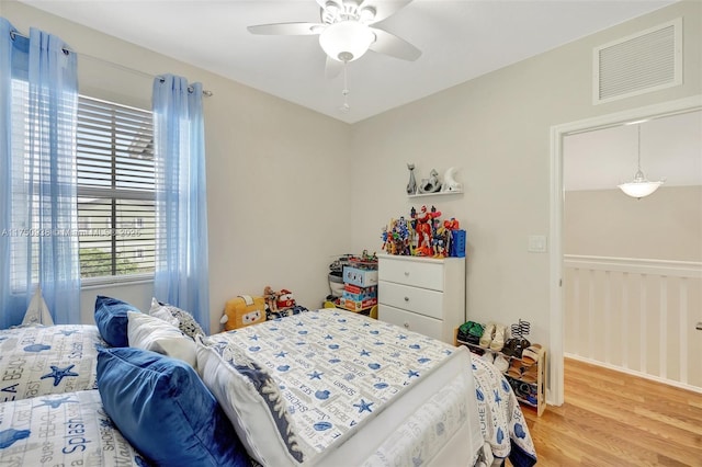 bedroom with light wood-type flooring, visible vents, and a ceiling fan