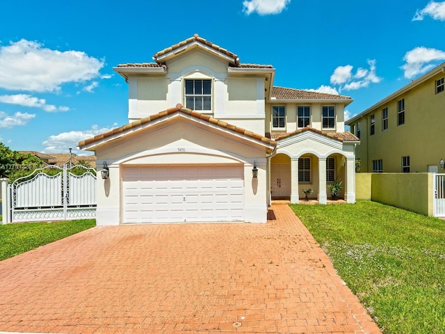 mediterranean / spanish home featuring a tile roof, decorative driveway, and fence