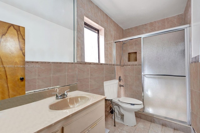 full bathroom featuring toilet, a shower stall, tile walls, and vanity