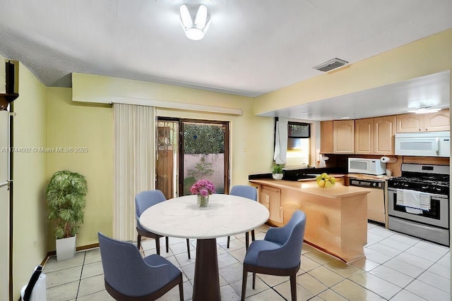 kitchen with light tile patterned floors, visible vents, light countertops, appliances with stainless steel finishes, and light brown cabinetry