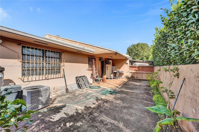 back of property featuring central air condition unit, stucco siding, fence, and a patio