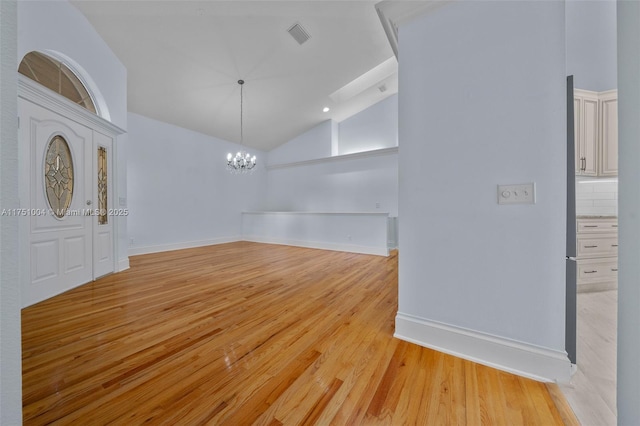 interior space with light wood finished floors, baseboards, a chandelier, and high vaulted ceiling