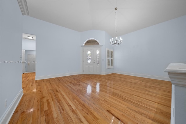 interior space featuring lofted ceiling, light wood-style floors, baseboards, and a chandelier