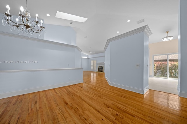 unfurnished living room with light wood-type flooring, baseboards, visible vents, and a glass covered fireplace