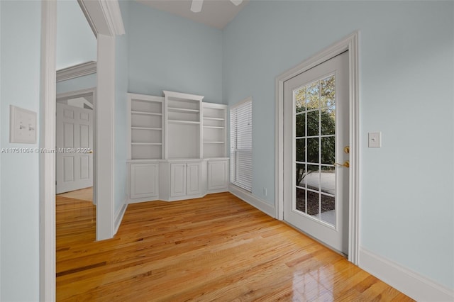 interior space featuring light wood-style floors, ceiling fan, and baseboards