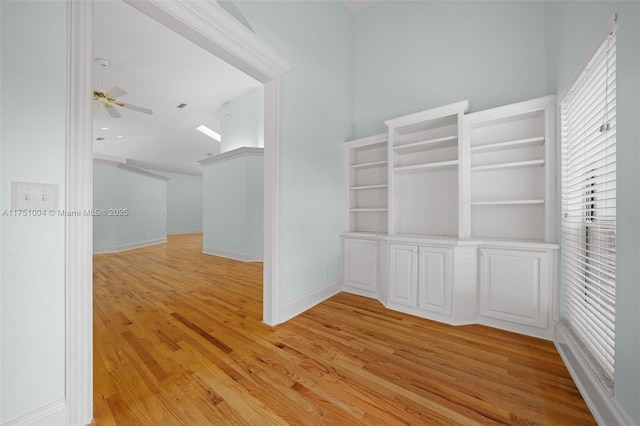 spare room featuring light wood-type flooring, ceiling fan, and baseboards