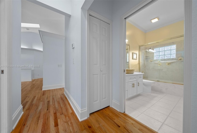 bathroom featuring bath / shower combo with glass door, a closet, wood finished floors, and vanity