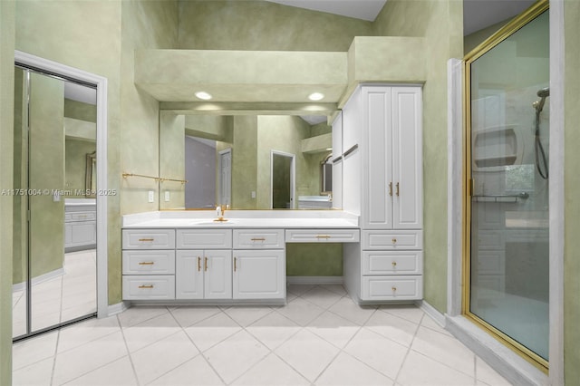 full bath featuring tile patterned flooring, vanity, baseboards, and a shower stall