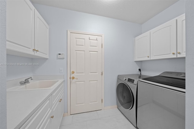 clothes washing area with marble finish floor, washing machine and clothes dryer, cabinet space, a sink, and a textured ceiling