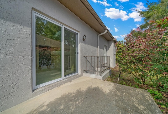 view of side of property with a patio and stucco siding