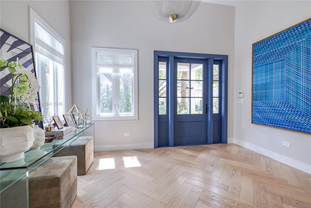 entryway featuring a towering ceiling and baseboards