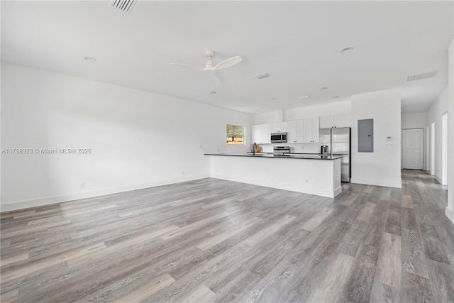 kitchen with appliances with stainless steel finishes, open floor plan, white cabinets, and visible vents