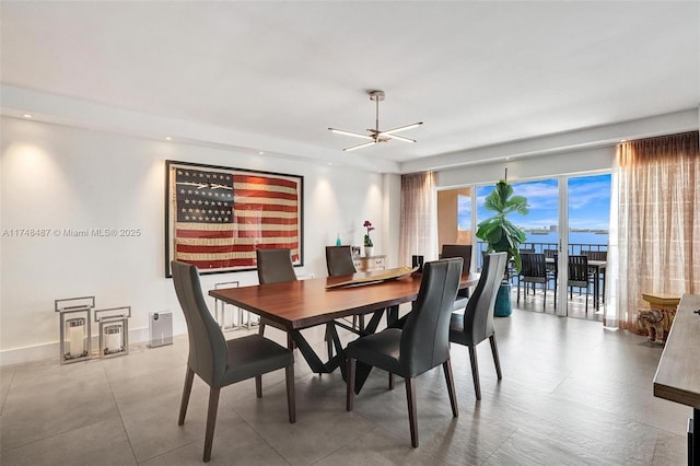 dining area with recessed lighting, a water view, and baseboards