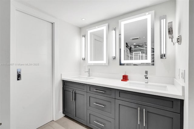 full bathroom with double vanity, tile patterned flooring, visible vents, and a sink