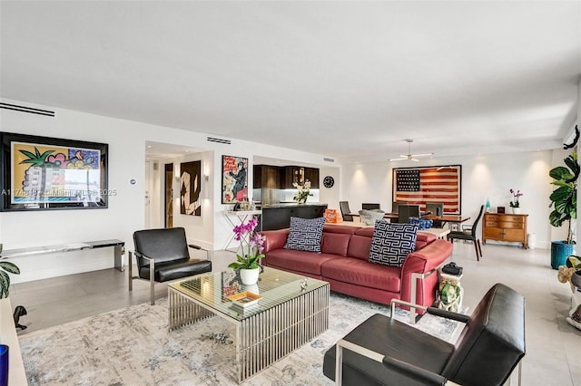 living room featuring ceiling fan, visible vents, and baseboards