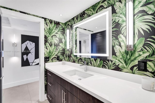 bathroom featuring baseboards, tile patterned flooring, vanity, and wallpapered walls