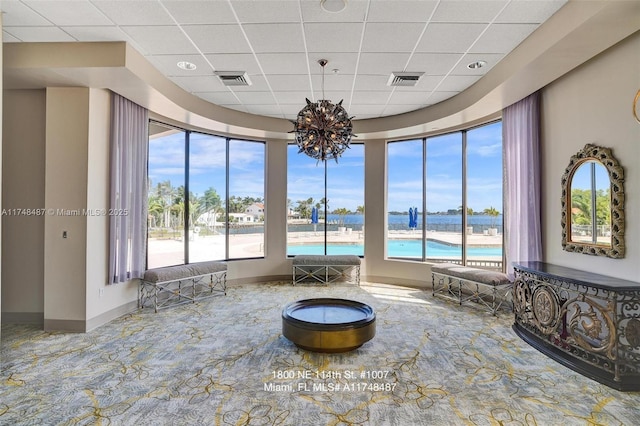 interior space with a paneled ceiling, visible vents, and a wealth of natural light