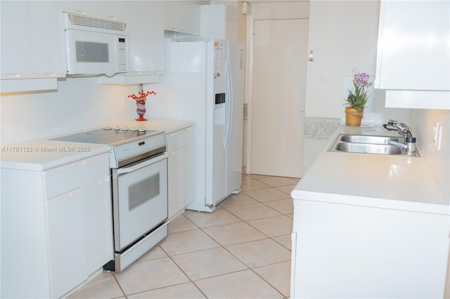 kitchen with white appliances, light countertops, a sink, and white cabinetry