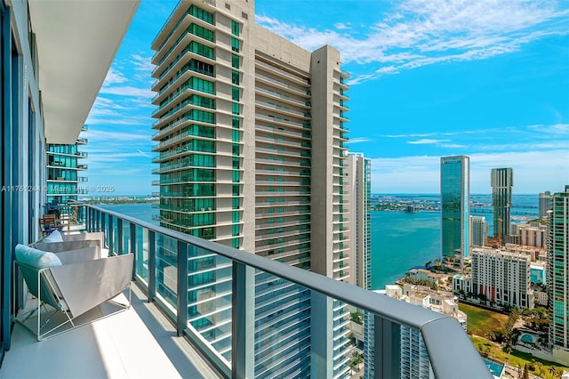 balcony featuring a water view and a city view