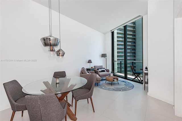 dining room featuring floor to ceiling windows, baseboards, and tile patterned floors