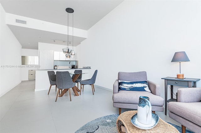 dining room with concrete flooring, visible vents, and track lighting