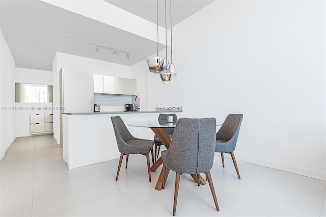 dining room featuring baseboards and track lighting