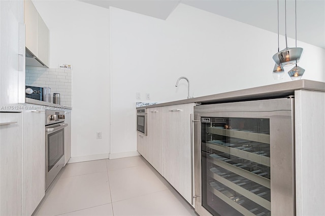 kitchen featuring light tile patterned floors, beverage cooler, stainless steel oven, light countertops, and hanging light fixtures