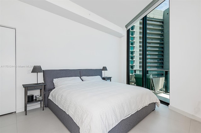 bedroom featuring expansive windows, multiple windows, and tile patterned floors