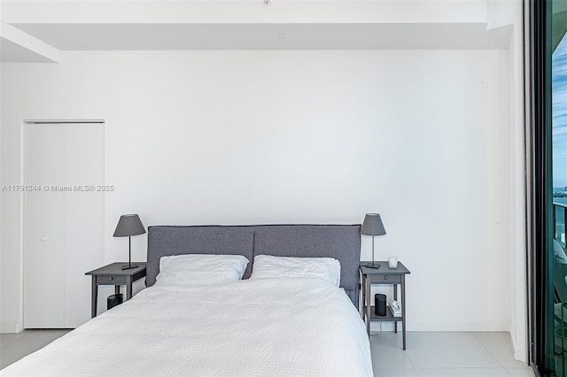 bedroom featuring light tile patterned floors and a closet