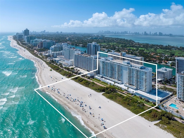 birds eye view of property with a beach view, a water view, and a city view