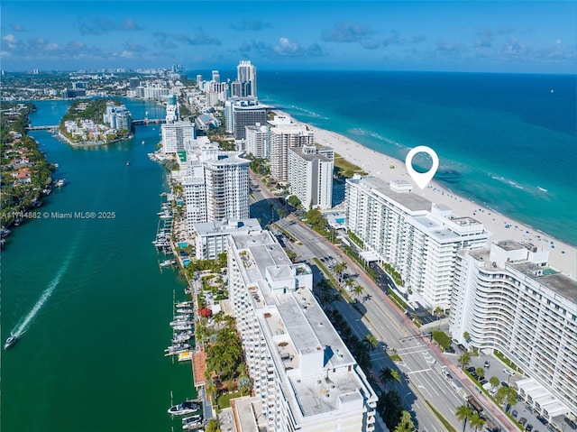 birds eye view of property with a water view, a view of city, and a view of the beach