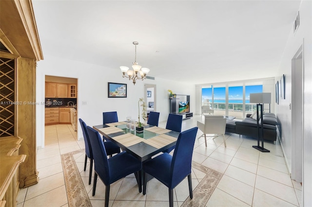 dining space with light tile patterned floors, visible vents, and an inviting chandelier