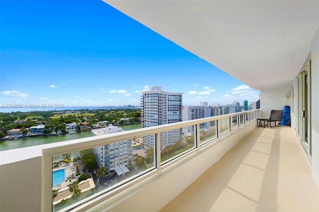 balcony featuring a water view and a city view