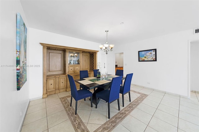 dining area featuring visible vents, a notable chandelier, baseboards, and light tile patterned floors