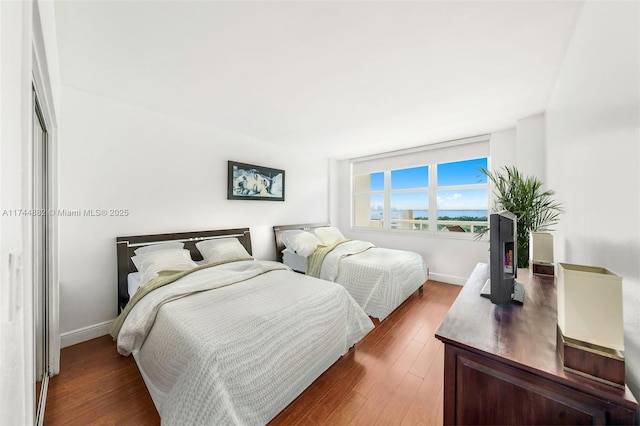 bedroom featuring baseboards and wood finished floors