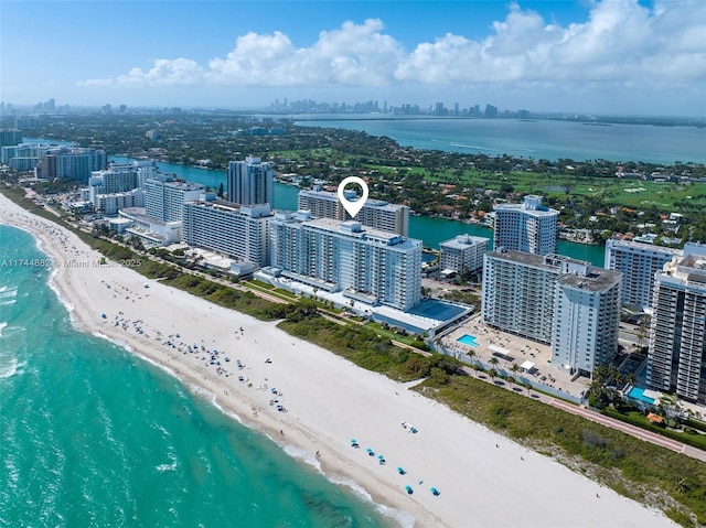 aerial view featuring a water view, a beach view, and a city view